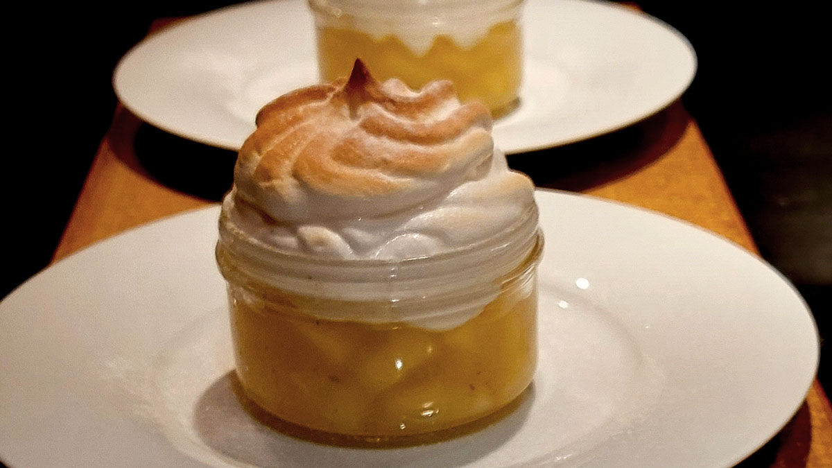 Ein Bergamotte-Rezept: Das Bild zeigt eine Glasschale, in dem ein Kompott aus Äpfeln und Birnen ist, darauf eine angeflämmte Meringue-Haube. Im Hintergrund eine zweite Portion.