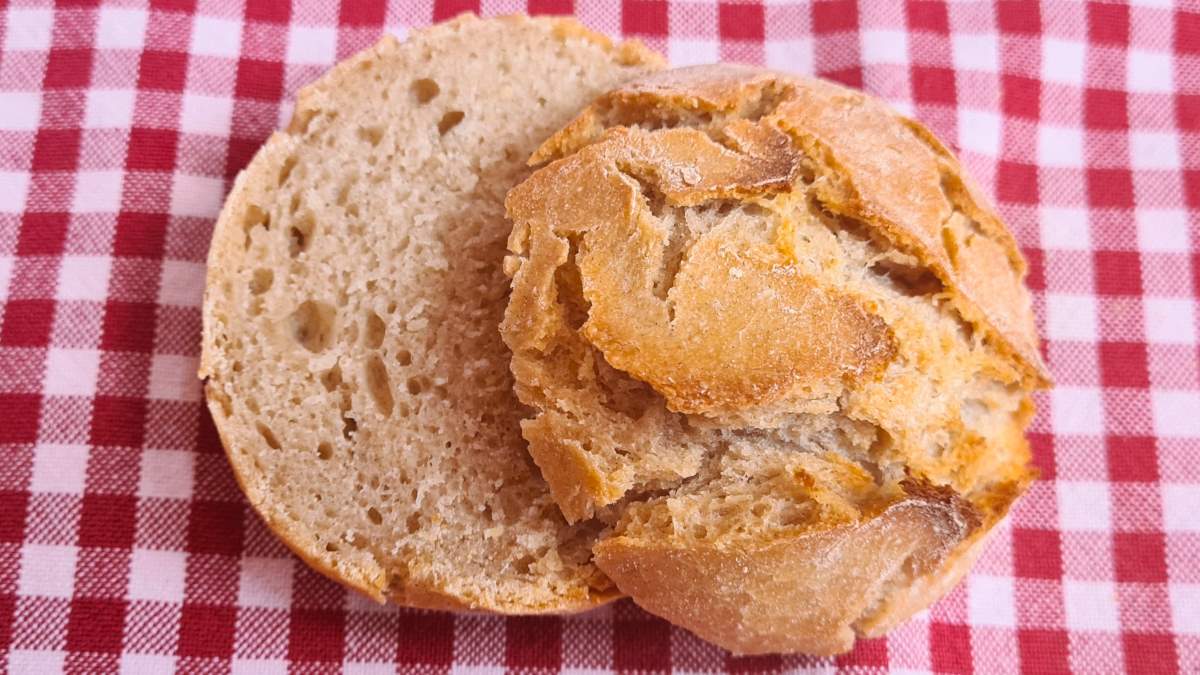 Man sieht ein einzelnes, halbiertes Gebäckstück vom Wachauer Laberln Versuch Nummer 1 auf einem rot-weiß-karierten Tuch