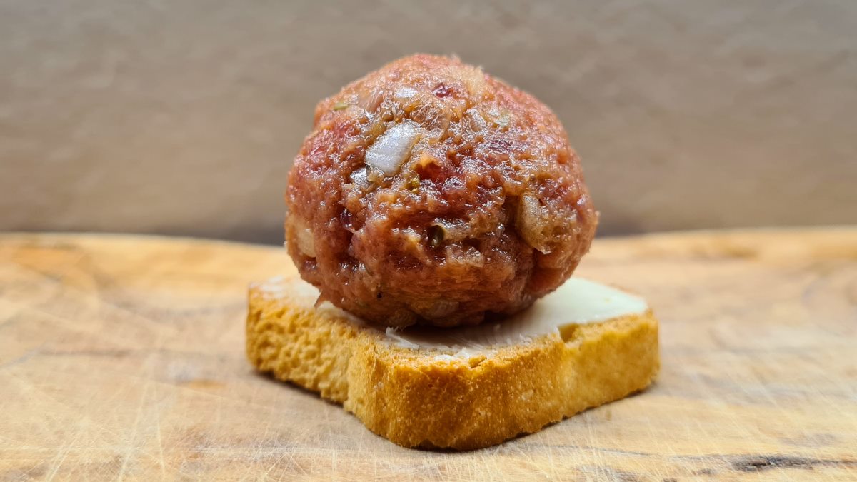 Beef Tatar als kleiner Genuss: Das Bild zeigt einen Minizwieback, bestrichen mit Butter, darauf eine Kugel Beef Tatar.