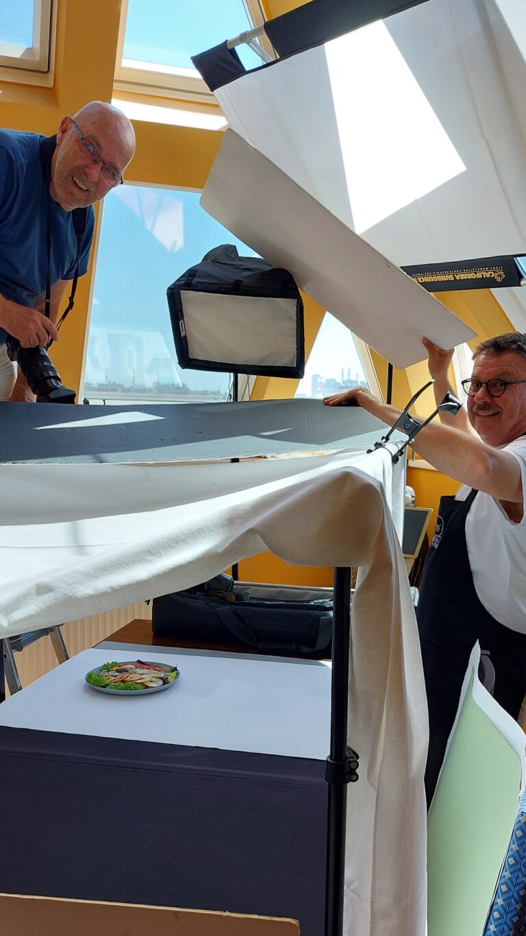Johannes hält einen Fotokarton hoch, um Licht abzudunkeln
