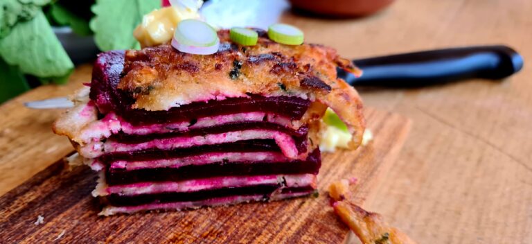 Zu einem Millefeuille geschichtete Scheiben von Kaspressknödeln und roten Rüben (rote Beete)