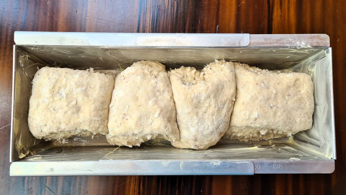 Die Teiglinge des Kokos-Toastbrots in der gebutterten Kastenform