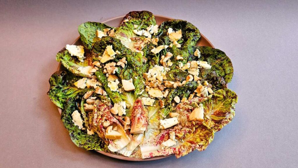 Ein Salat aus Forellenschluss mit gehackten Nüssen und Käsestücken