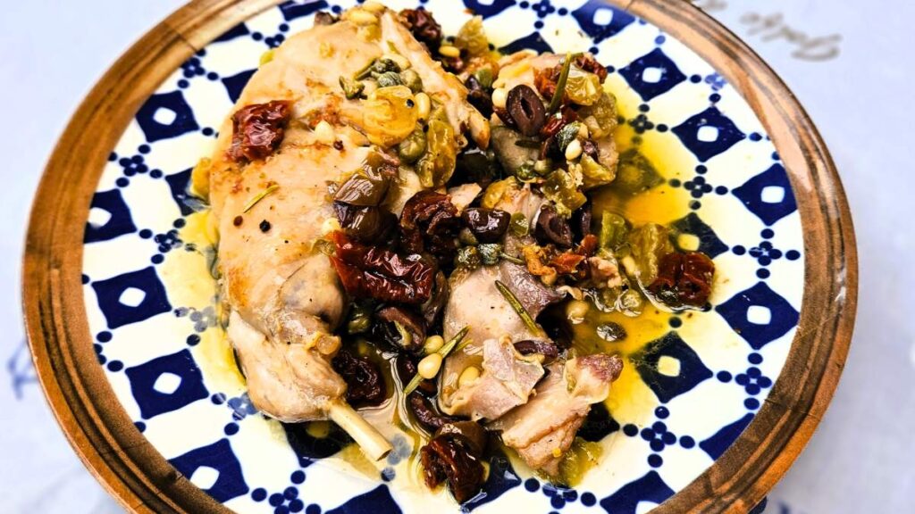 Das Bild zeigt das engerichtete Kaninchen auf mediterrane Art auf einem mediterran inspirierten Teller
