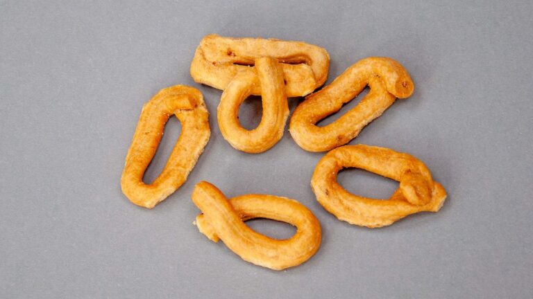 Ein paar Taralli liegen auf einer grauen Fläche