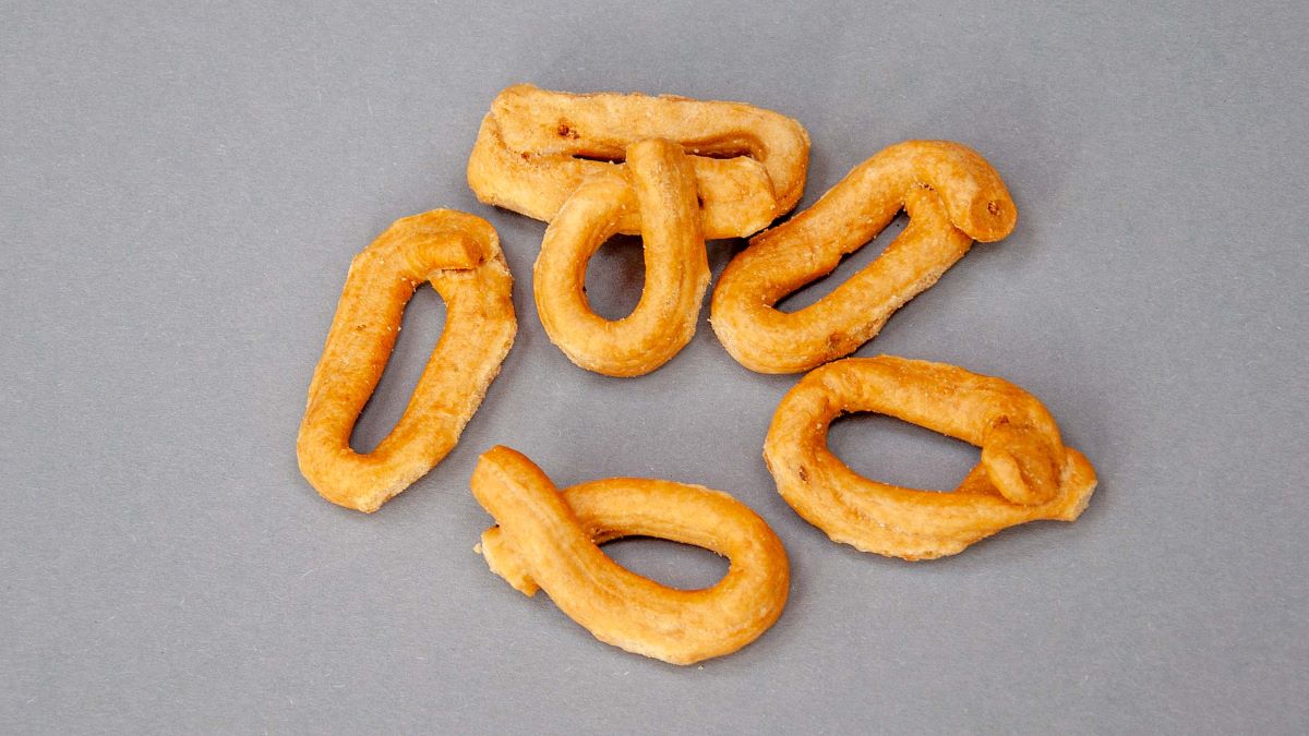 Ein paar Taralli liegen auf einer grauen Fläche