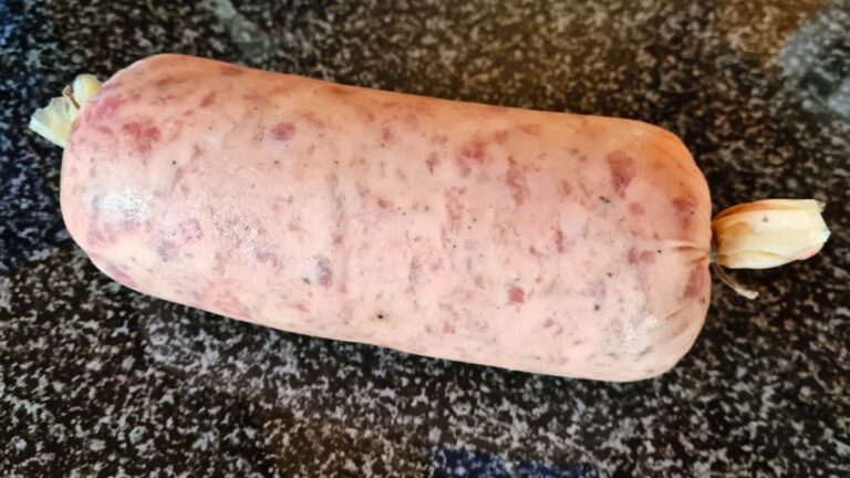 Das Bild zeigt eine rohe Wurst, ein Musetto auf einer Arbeitsplatte
